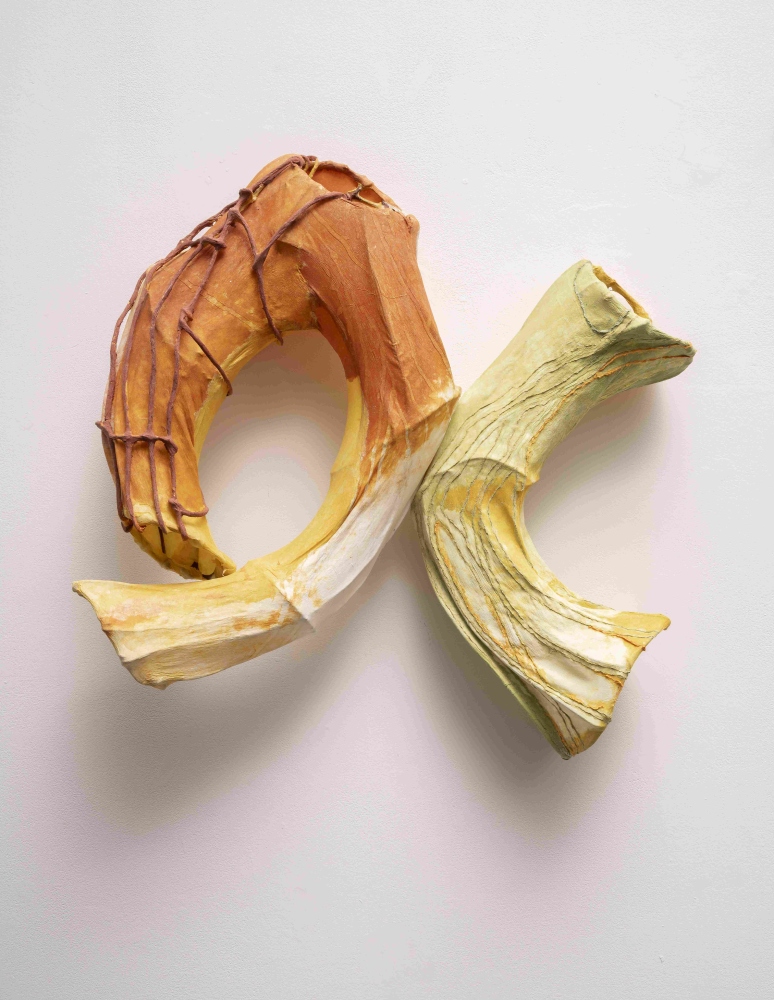 Paper wall sculpture of two forms resembling tree roots