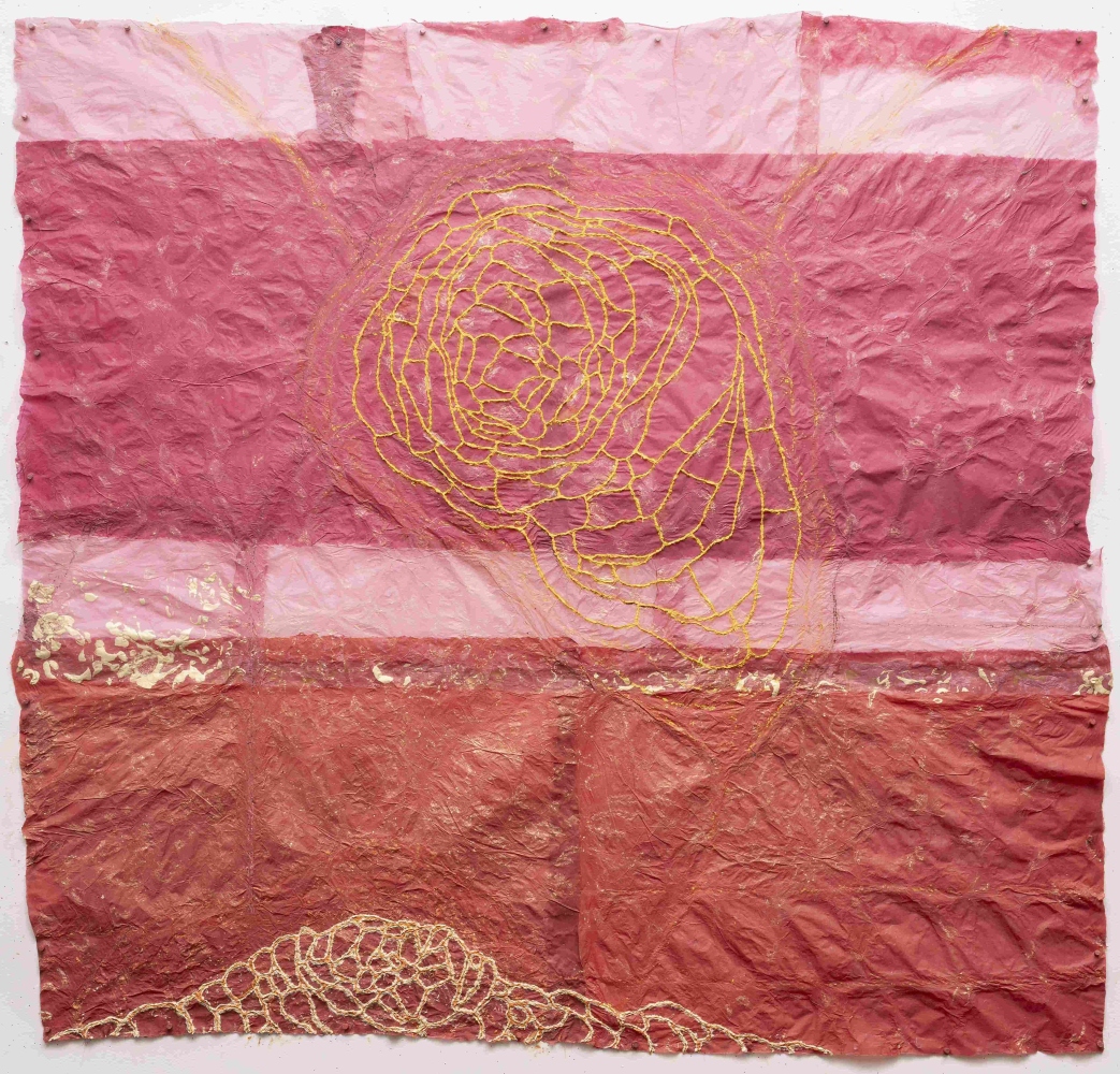 Pink and red handmade paper drawing with a yellow web shape in the center