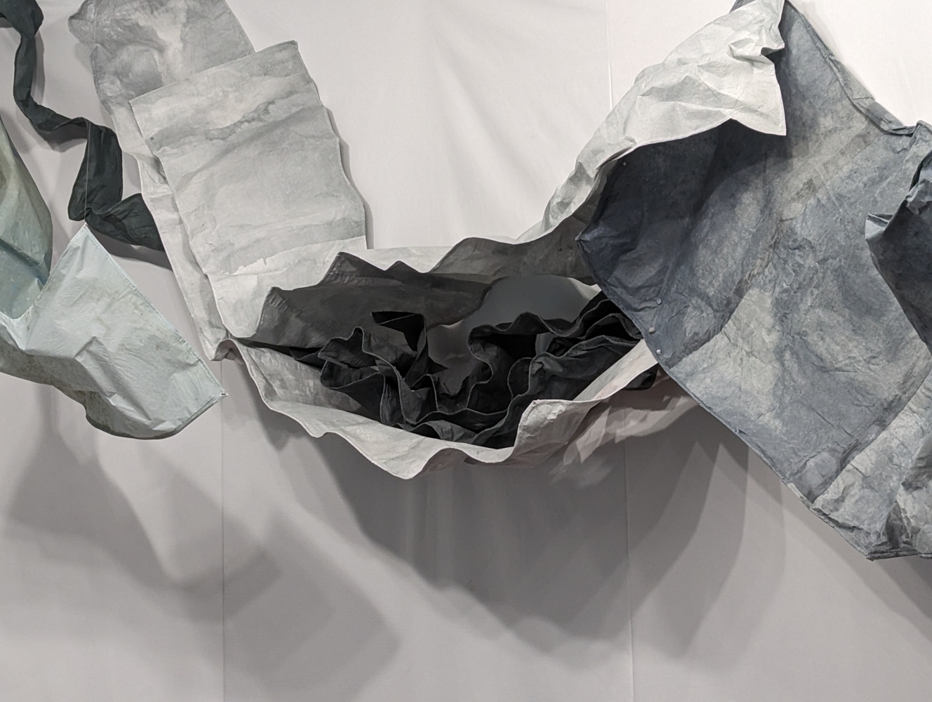 light gray sheets of handmade paper surrounding dark gray ones