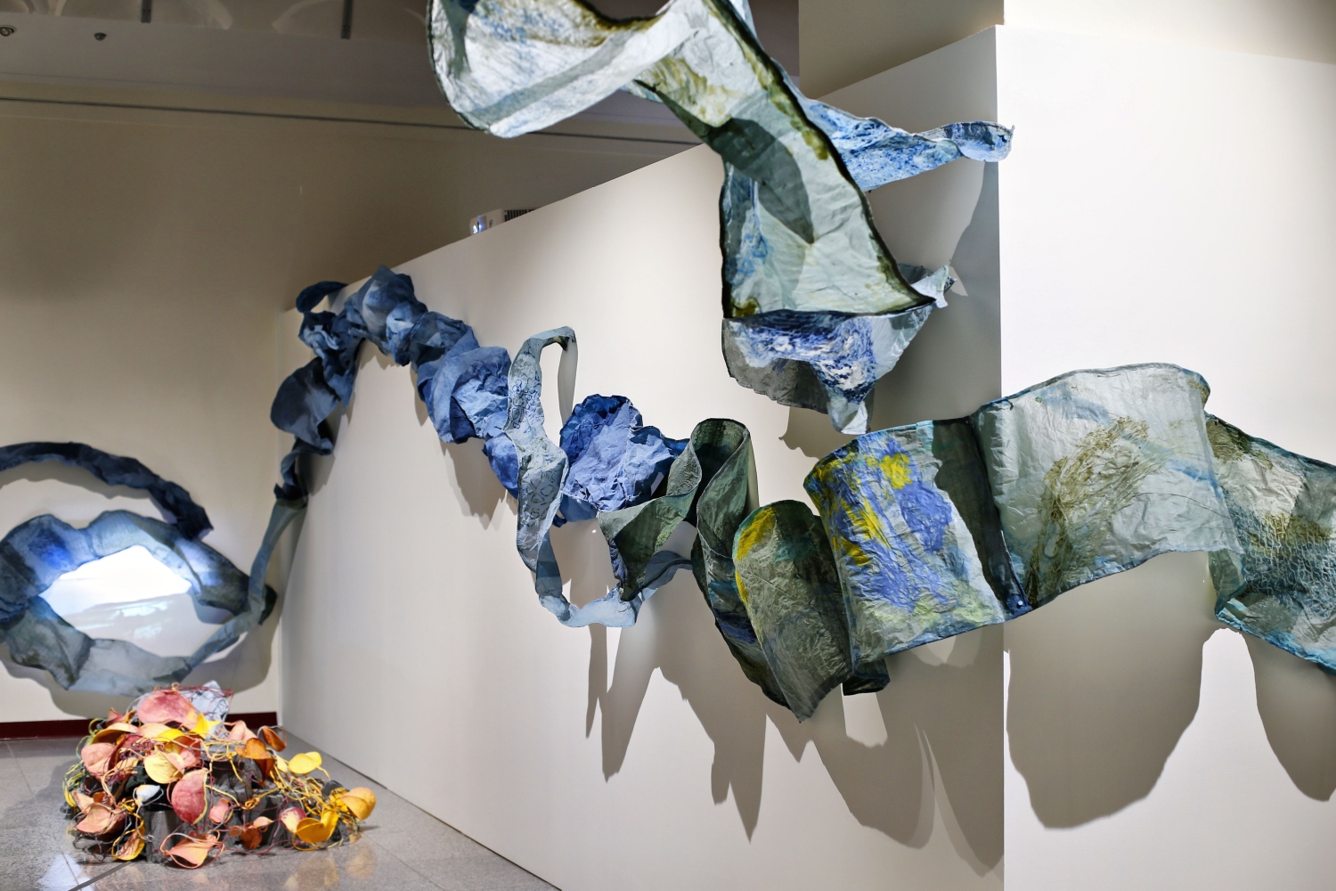 coral sculpture on the floor surrounded by blue paper waves