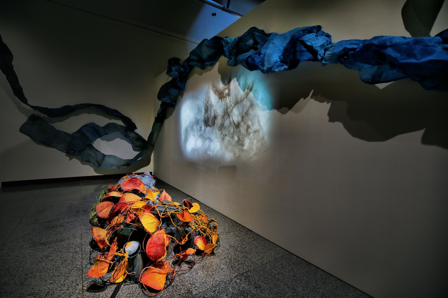 coral sculpture on the floor surrounded by blue paper waves