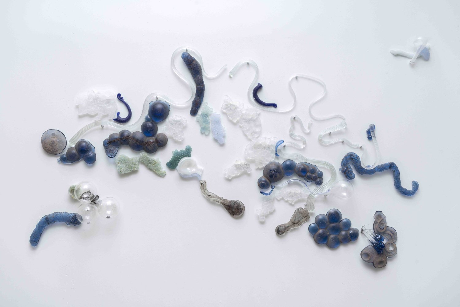 glass wall installation in clear and blue glass that feels like walking along a river bank