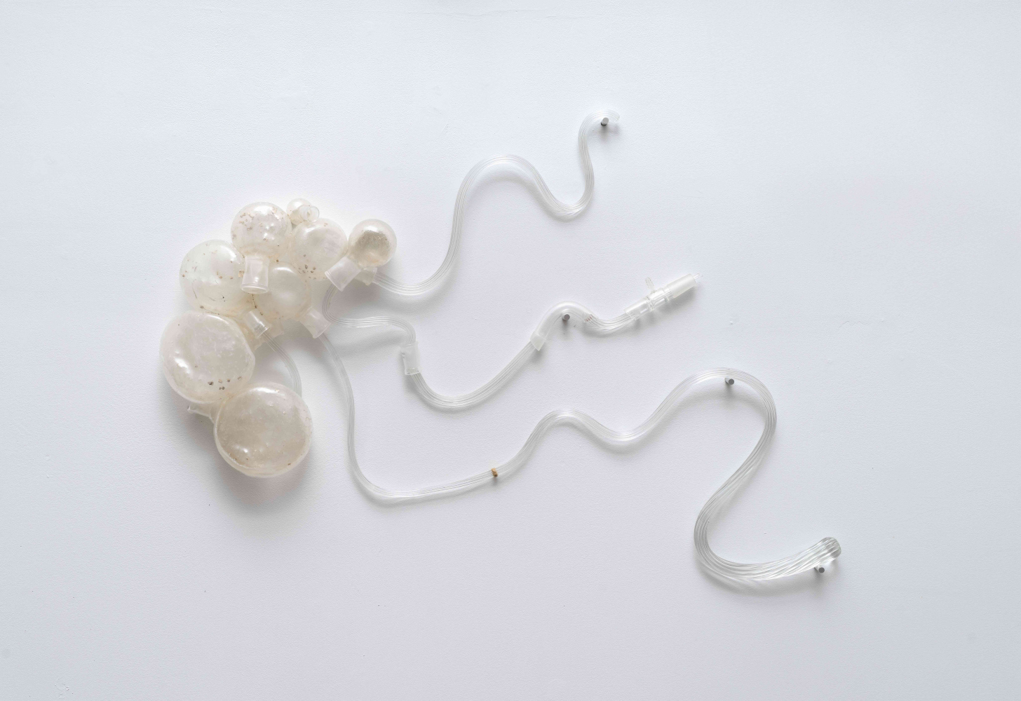 Abstract glass wall sculpture with the forms of river curves coming out of a river bank