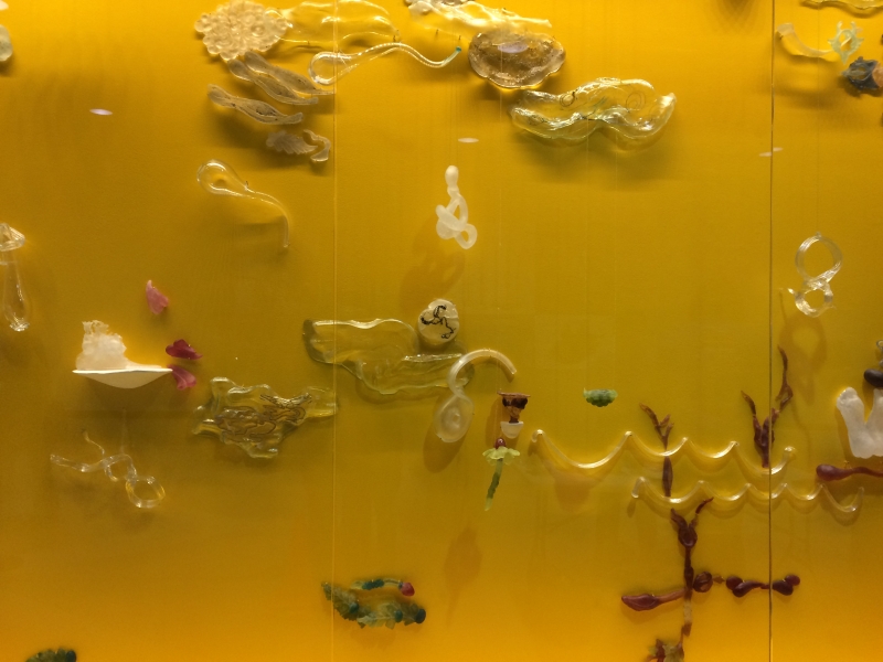 yellow wall with glass shapes evoking buddhist iconography