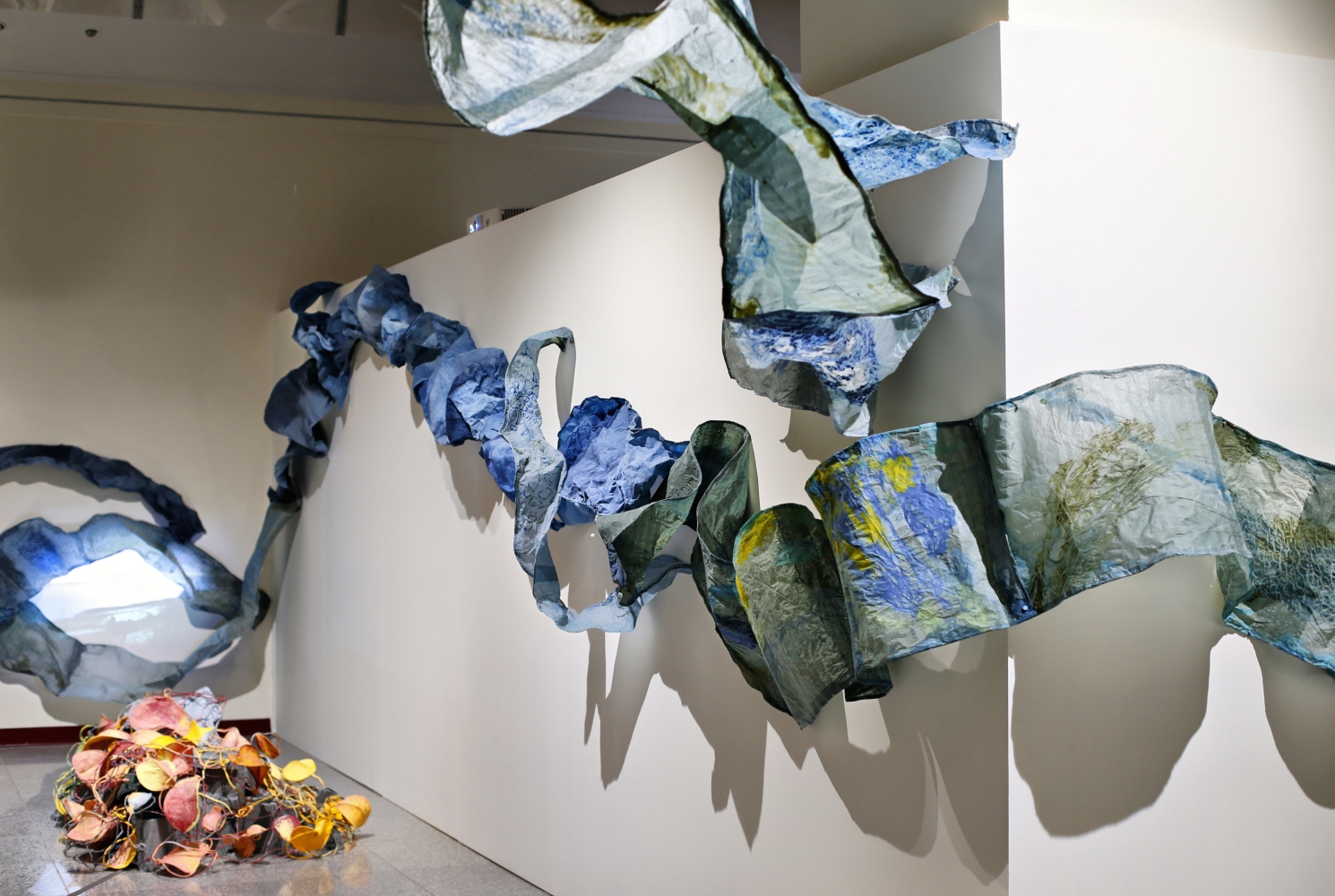 installation shot of once she dries of blue papers expressing being underwater
